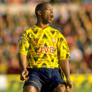 Soccer player in a yellow and blue uniform with 'JVC' branding on a field.
