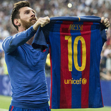 Messi holding a Barcelona jersey with the number 10 in a stadium setting
