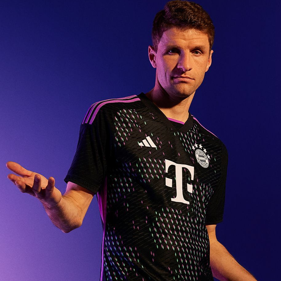 Person wearing a black sports jersey with visible branding on a purple background