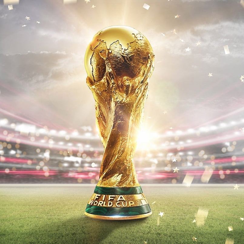 World cup trophy on a football field with confetti falling