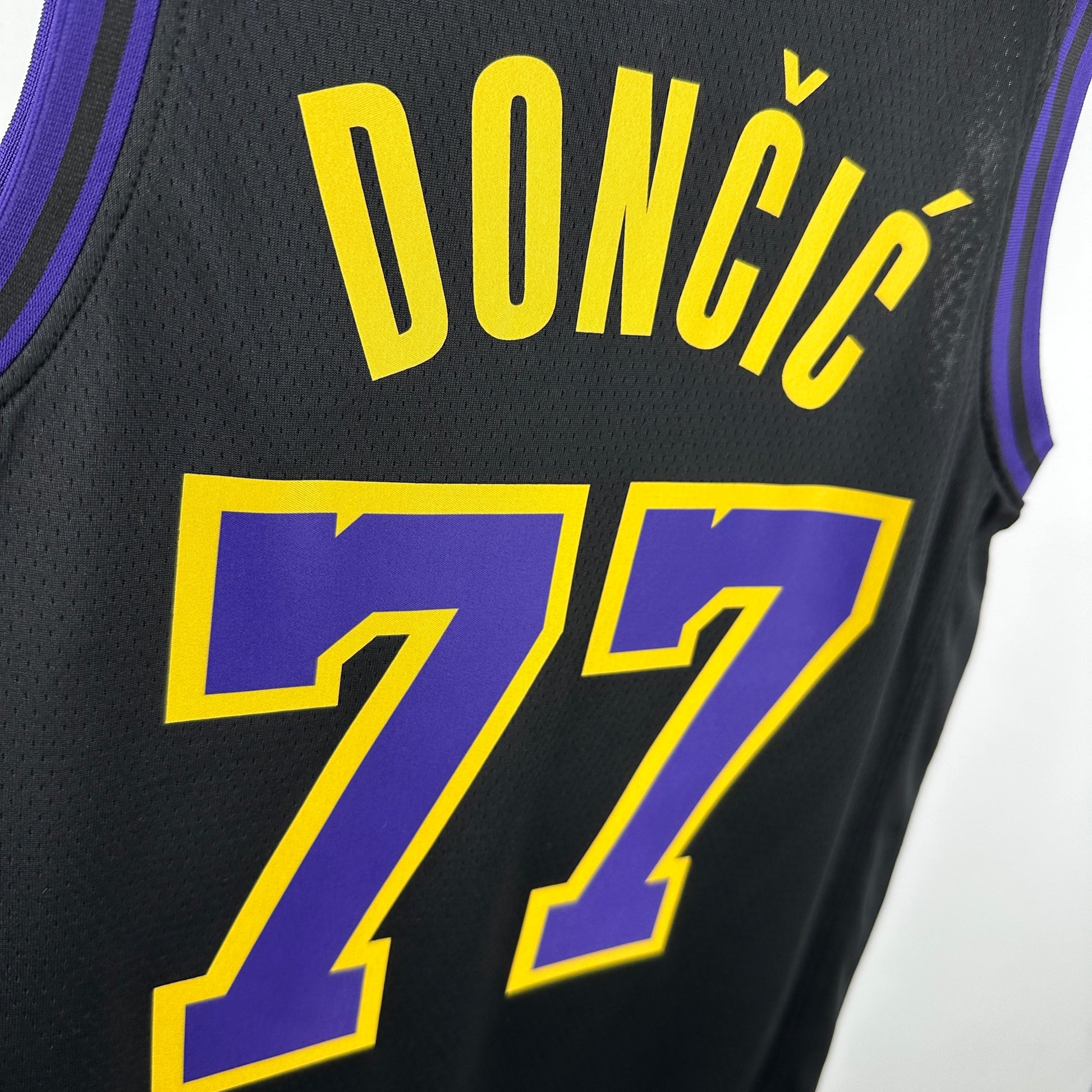 Los Angeles Lakers 2025/26 City Edition swingman jersey Luka Dončić number 77 black purple gold front and back view