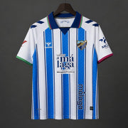 Malaga Home Jersey 2026/27 front view with blue and white vertical stripes