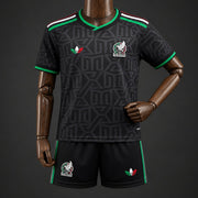 Mexico Third Jersey 2026 Kids Set front view with black patterned jersey, green trim, national colour shoulder accents and matching shorts