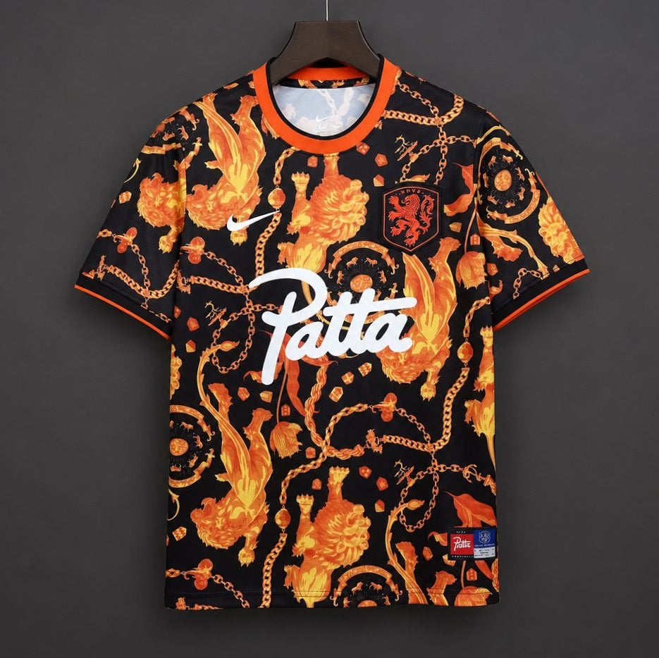 Netherlands x Patta Pre-Match Jersey 2026 front view with black base, orange all-over graphic print, Netherlands crest and bold chest graphic