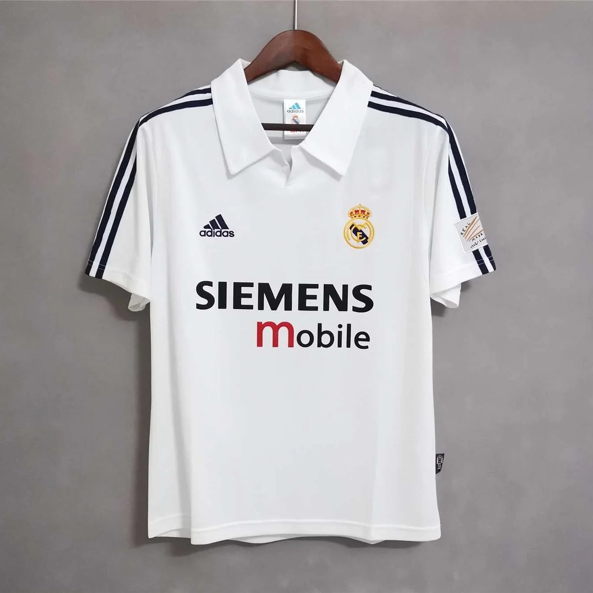 Front view of the Real Madrid Home Jersey 2001/02 in white with club crest, fold-over collar, dark shoulder stripes and Siemens Mobile sponsor