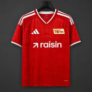 Union Berlin Home Jersey 2026/27 front view with red patterned design and Raisin sponsor