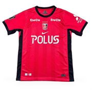Urawa Red Diamonds Home Jersey 2026/27 front view in red with black side panels, club crest and POLUS sponsor
